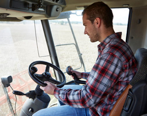 a young man behind the wheel of a tractor